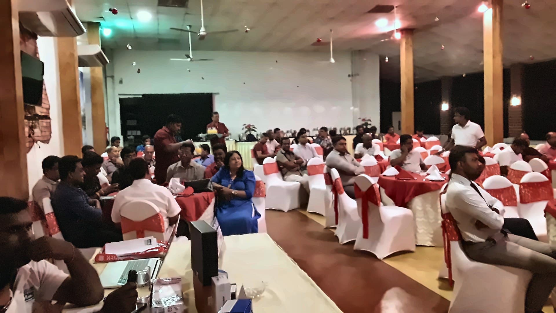 Guests seated in the hall at tables with white chair covers